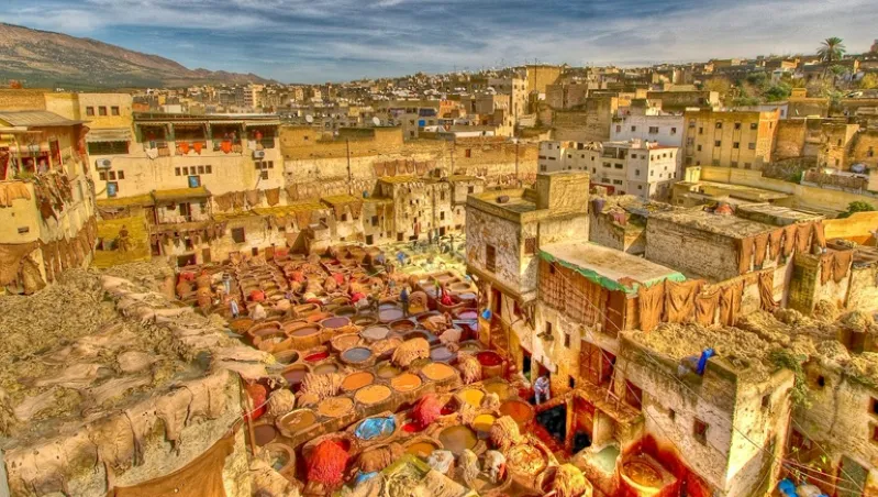 A bustling Moroccan city scene filled with diverse crowds of people engaging in daily activities: Morrocon Guided Tour